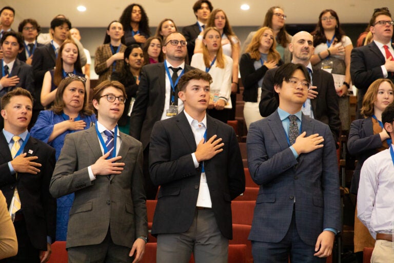 Students attending Model Constitutional Convention with their hands over their hearts.